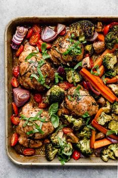 a pan filled with chicken, broccoli, carrots and other veggies