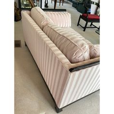 a striped couch sitting on top of a floor next to a mirror