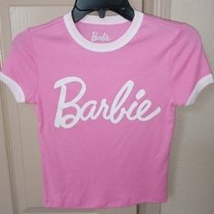 Barbie T-Shirt. Pink Trimmed In White. Size Xs. Basic Logo Print Top For Spring, Basic Spring Top With Logo Print, Basic Logo Print T-shirt For Spring, 90s Pink Tops With Logo Print, Pink 90s Logo Print Tops, 90s Pink Logo Print Tops, 90s Style Pink Tops With Logo Print, Cute Spring Tops With Logo Print, Cute Logo Print Tops For Spring