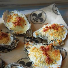 several oysters with cheese and sauce on a plate