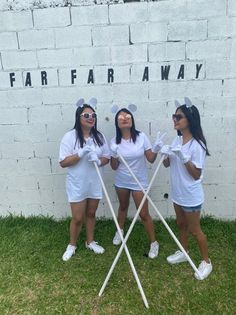 three girls dressed in white are posing for the camera