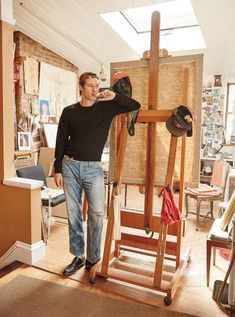 a man standing next to an easel in a room