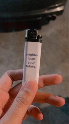 a hand holding a lighter that says brighter than your future on the back of it