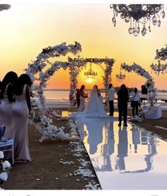 the bride and groom are walking down the aisle to their wedding ceremony on the beach