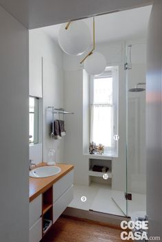 a bathroom with white walls and wooden floors