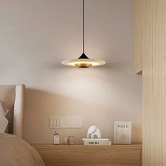 a bed room with a neatly made bed and a light hanging from the ceiling above it