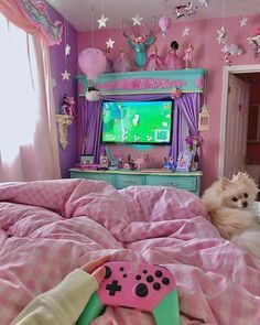 a small dog laying on top of a bed next to a pink comforter and tv