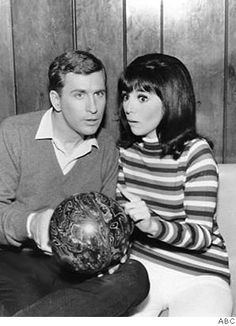 a man and woman sitting on a couch holding bowling balls