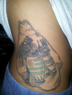 a tattoo on the side of a woman's stomach with two people holding ketchup cans