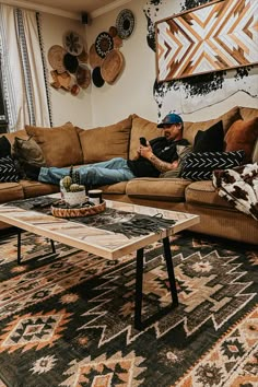 a man laying on top of a couch in a living room