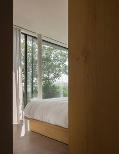 a bed sitting next to a window in a bedroom