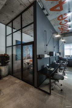 an office with glass walls and black desks