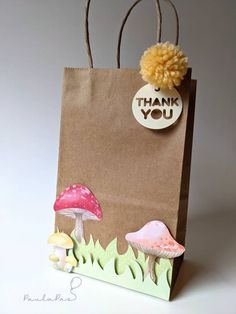 a brown paper bag with mushrooms on it and a thank you tag hanging from the front