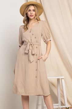 Elevate your wardrobe with our Asymmetrical Button-Down Wrapped Midi Dress, a true embodiment of timeless elegance and style. This dress offers a perfect blend of sophistication and modern flair, ensuring you'll look effortlessly chic and feel confident on any occasion. Key Features: Half-Sleeve Design: The dress features a half-sleeve with button closure, providing a touch of modesty and versatility. You can adjust the sleeves to your preference, making it suitable for various weather condition Cheap Brown Dress With Button Closure, Classic V-neck Midi Dress With Buttons, Formal Beige Dress With Asymmetrical Hem, Spring Belted Dress With Asymmetrical Hem, Spring Midi Dress With Asymmetrical Hem And Belt, Solid V-neck Dress With Button Cuffs, Beige A-line Dress With Button Closure, Elegant Summer Midi Dress With Covered Buttons, Midi Workwear Dress With Button Closure