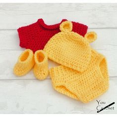 two crocheted sweaters and booties are laying on a white wooden surface