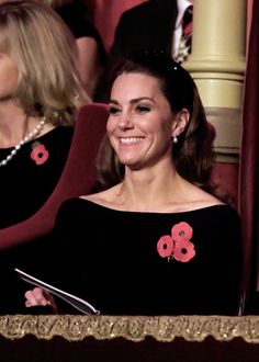 a smiling woman in a black dress sitting at a table