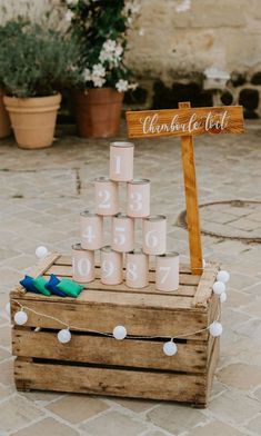 a wooden crate filled with candles next to a sign