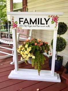 a sign that says family on it with flowers in the potted planter next to it