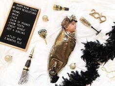 a baby doll laying on top of a white blanket next to other toys and decorations