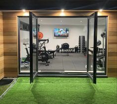 the inside of a gym with exercise equipment and artificial grass in the flooring area