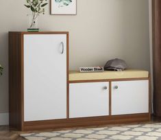 a white and brown cabinet sitting next to a potted plant on top of a wooden shelf