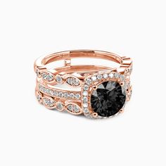 a rose gold ring set with an oval black diamond surrounded by smaller round white diamonds