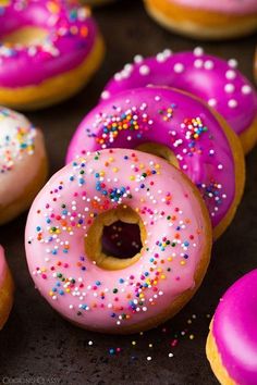 there are many donuts with pink frosting and sprinkles