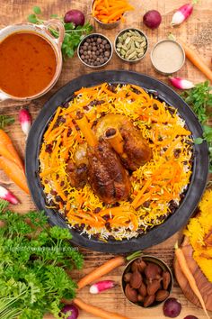 an assortment of food including carrots, rice and beans on a wooden table with spices