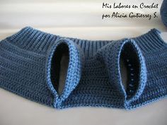 there is a blue knitted sweater with two holes in the front and one hole in the back