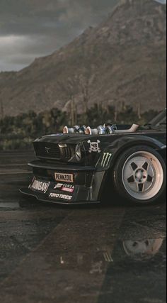 a black car parked in front of a mountain