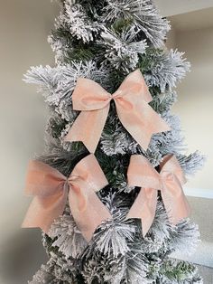 a decorated christmas tree with pink bows