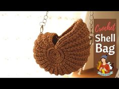 a crochet shell bag hanging from a chain