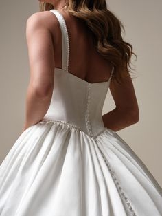 a woman in a white wedding dress looking back