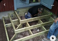 two men are working on a wooden structure