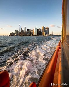 the city skyline as seen from a boat on the water with waves in front of it