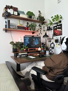 a person sitting at a desk with headphones on and looking at a computer screen