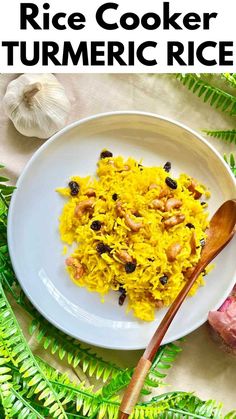 rice cooker turmeric rice on a white plate with a wooden spoon next to it