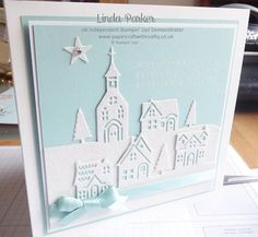 a card with a paper cut out of a church in the background and a star on top