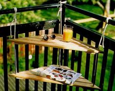 a wooden shelf with two shelves holding magazines and glasses on top of it next to a glass of orange juice