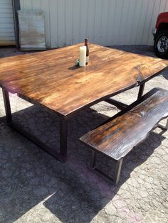 a wooden table with two benches and a bottle of wine sitting on top of it