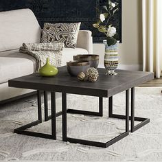 a living room with a couch, table and vases on the coffee table in front of it