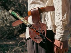 a person with a knife and some scissors in their back pocket, while holding something