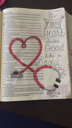 an open bible with a drawing of a stethoscope in the shape of a heart