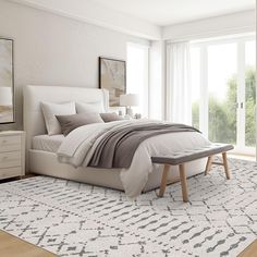 a bedroom with a large bed and white furniture