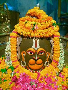 an idol is surrounded by flowers and other decorations