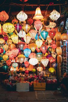 many colorful lanterns are hanging from the ceiling