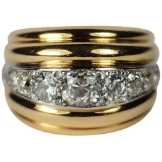 A dramatic gold and diamond dome ring in the style of Belperron, designed as five curving ridges, the central ridge set with diamonds in platinum. The 9 main diamonds are old transitional cut stones, which are interspersed with 8 smaller single-cut diamonds. The central stone is estimated to weigh 1.15 carats, with a total diamond weight of approximately 4 carats. The stones are bright and lively. The ring is marked with the eagle’s head poinçon for French manufacture, but no maker’s mark is vis Cocktail Rings Diamond, Stacked Wedding Rings, Rough Diamond Ring, Crossover Ring, Chalcedony Ring, Gold Rings Fashion, Dome Ring, Tourmaline Jewelry, Rings Diamond