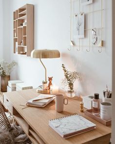 a wooden desk topped with a lamp next to a book shelf and other office supplies