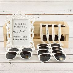 there are many pairs of sunglasses in front of a sign that says don't be blinded by our love please take some shades