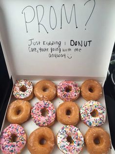 a dozen donuts in a box with sprinkles on them are shown